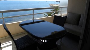 Varanda com mesa e cadeiras, com vista para um corpo de água e barcos.