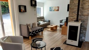 Una sala de estar moderna con un sofá, dos sillones, una mesa de centro y una chimenea.