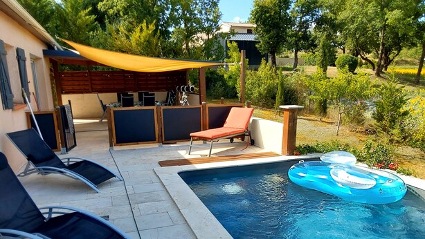 Una piscina con sillas de descanso y una sombrilla.