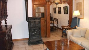 A living room with a wooden coffee table, a sofa, a chandelier, and a fireplace. - Charming cottage classified 3 stars in an old renovated mill. Comfort. (Schoenbourg)