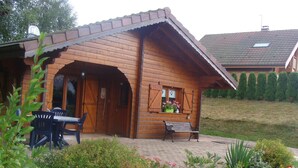 Una cabaña de madera con un patio, una mesa y sillas.