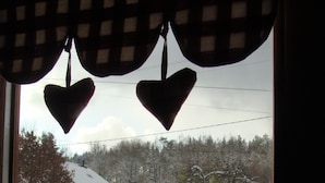 Un paisaje nevado con una casa y árboles cubiertos de nieve.