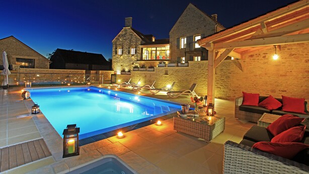 A swimming pool with lounge chairs and a covered seating area with cushions. - Charming house with private pool near Sarlat in beautiful grounds (Sarlat-La-Canéda)