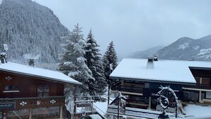 A snow-covered mountain landscape with buildings in the foreground.