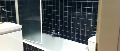 Een badkamer met een wit bad, een wit wastafel en een toilet.
