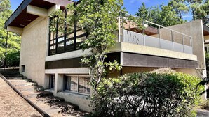Ein modernes, zweistöckiges Gebäude mit flachem Dach, großen Fenstern und einer Betonfassade.