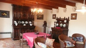 Ein Essbereich mit Holztisch, Stühlen und einer Chandelieber.