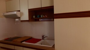 A kitchen with a built-in stove, a sink, and wooden cabinets.