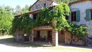A rustic stone house with a covered porch and green shutters. - Mas Cevenol with pool in Gagnieres (Gagnières)