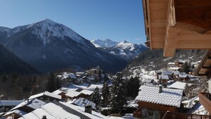 Un pueblo cubierto de nieve con casas de madera tradicionales y una vista despejada de la cordillera.