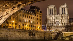 Un bâtiment historique avec un grand pont en arc de cercle en premier plan.