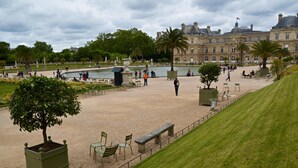 Un vaste espace extérieur agrémenté d’une fontaine, de sièges et d’un grand bâtiment en arrière-plan.