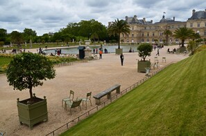 A spacious outdoor area with a fountain, seating, and a large building in the background.