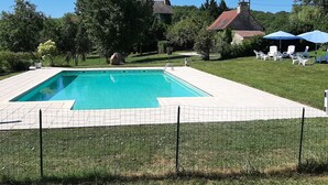 A rectangular swimming pool with a tiled deck, surrounded by a grassy area and a fence. - Beautiful view of the countryside house 8 pers pool Wifi near Sarlat (Salviac)