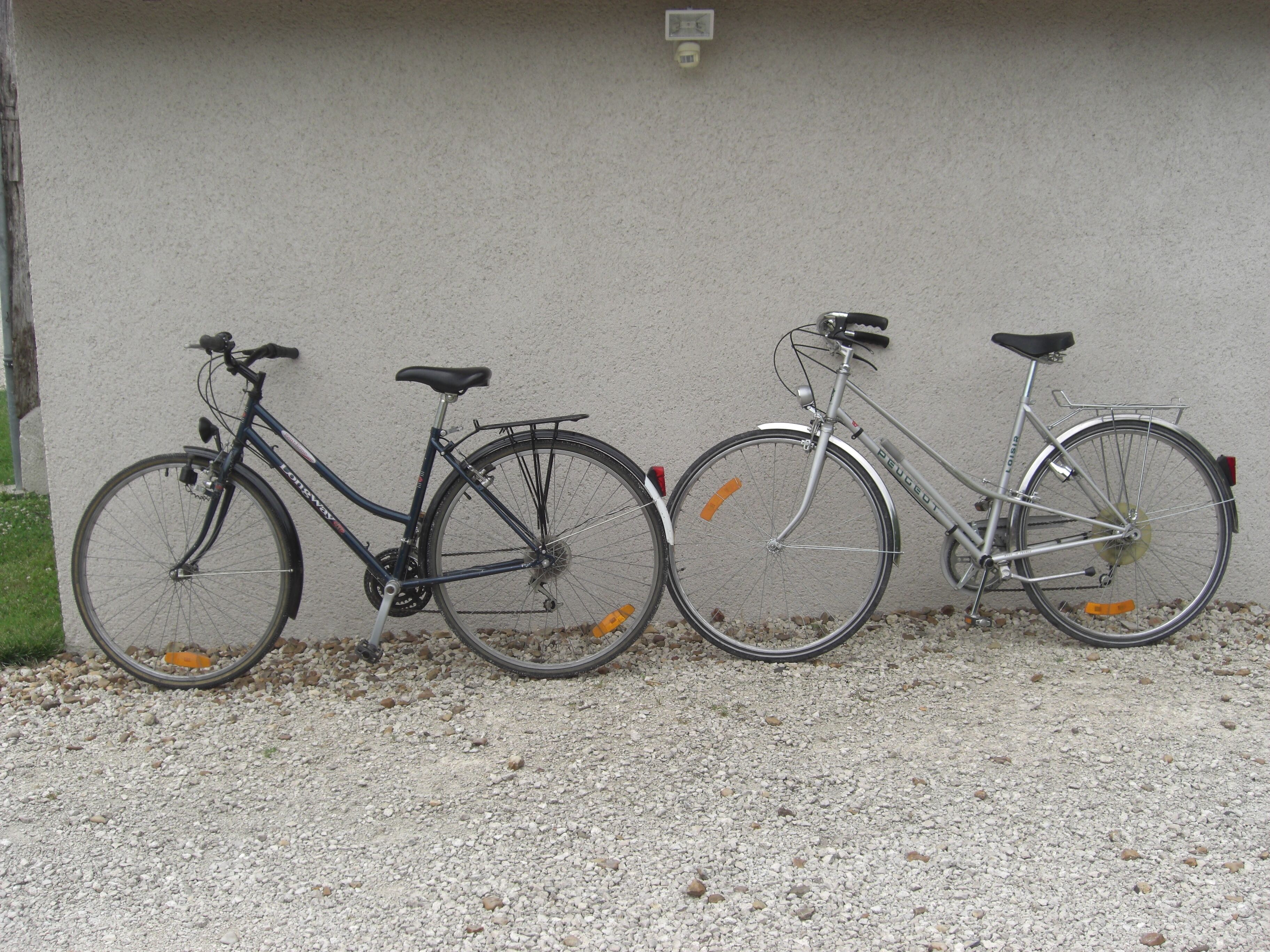 Trois vélos sont garés contre un mur.