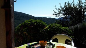 A table set outdoors with a view of a mountainous landscape. - Quiet chalet, between sea and mountain (Isolaccio-Di-Fiumorbo)