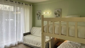 Ein Schlafzimmer mit einem Etagenbett, einer Schlafcouch und zwei Wandleuchten.