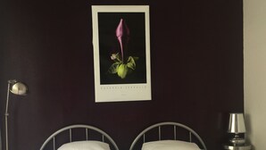 A bed with two white pillows and a framed picture of a flower on the wall. - A beautiful, quiet 3-star apartment in a wooded park with a view of the bay (Cassis)