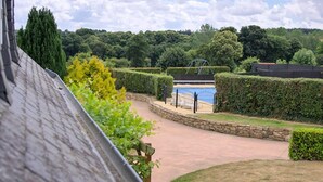 A landscaped garden with a swimming pool, stone pathways, and neatly trimmed hedges. - House with private indoor pool and 29° sauna. Summer 2027: Private Indoor and Outdoor Pools (Boqueho)