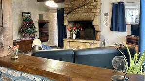 A cozy interior with a stone fireplace, wooden beams, a Christmas tree, and a seating area. - House with private indoor pool and 29° sauna. Summer 2027: Private Indoor and Outdoor Pools (Boqueho)