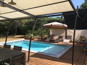 A pool area with a covered deck, lounge chairs, and a table. - Villa with swimming pool, large terrace, all comfort, enclosed garden, calm. (Forcalqueiret)