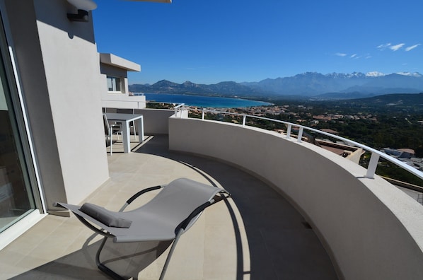 Un balcon avec vue sur les montagnes et un lac.