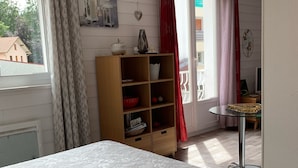 A bedroom with a bed, a wooden cabinet, and a desk with a chair.