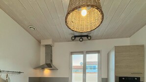A modern kitchen with wooden cabinets, a built-in oven, a microwave, a sink, and a large window. - 3-STAR HOUSE IN LA COTINIERE, 50 M FROM THE FISHING PORT (saint pierre d oleron)