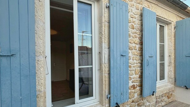 A stone building with blue shutters, a wooden deck, and a clear sky. - 3-STAR HOUSE IN LA COTINIERE, 50 M FROM THE FISHING PORT (saint pierre d oleron)