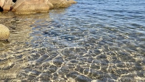 A clear view of a rocky shoreline with calm water and a distant view of a coastline. - Stone house with panoramic views over the bay of Figari, outdoor spa (Pianottoli-Caldarello)