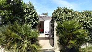 A pathway leading to a building with a covered outdoor seating area. - Small house in the heart of nature, 4 km from Cargèse. (Cargèse)