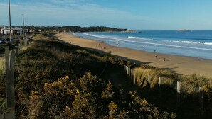 A beach with a sandy shore, waves, and a clear sky. - Modern villa in Les Sables d'Or with heated pool (Plurien)