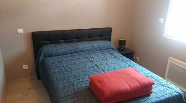 A small, neatly made bed with a blue quilt and a red blanket, a bedside table with a lamp, and a window with a view of the outside. - COSY HOUSE MOUNTAIN VIEW, ON ORLU GARDEN 5mn AX LES THERMES IDEALE FAMILLE (Orlu)
