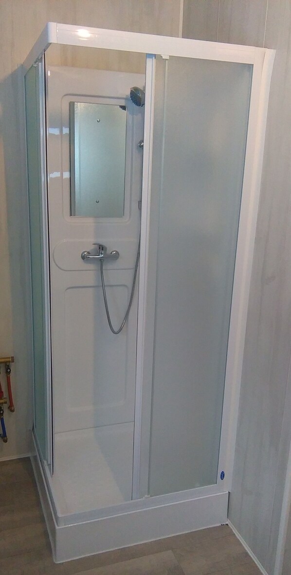 A glass-enclosed shower stall with a white frame, a showerhead, and a control knob. - COSY HOUSE MOUNTAIN VIEW, ON ORLU GARDEN 5mn AX LES THERMES IDEALE FAMILLE (Orlu)