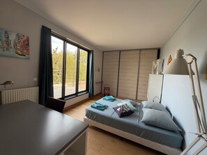 A bedroom with a bed, a desk, a radiator, a window with curtains, and a painting on the wall. - 5* air-conditioned villa between the Bassin d'Arcachon and the ocean. Pets allowed (Lège-Cap-Ferret)