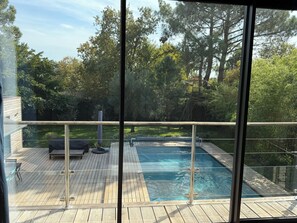 A wooden deck with a pool, outdoor furniture, and a view of a forested area. - 5* air-conditioned villa between the Bassin d'Arcachon and the ocean. Pets allowed (Lège-Cap-Ferret)