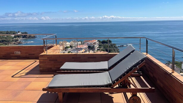 A terrace with two lounge chairs and a view of the sea. - Luxury penthouse with terrace and jaquzzi the panoramic sea views (LLANÇA)