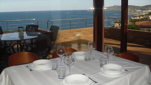 A table set for dining with a view of the ocean and hills. - Luxury penthouse with terrace and jaquzzi the panoramic sea views (LLANÇA)