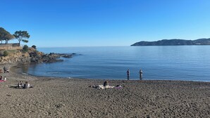A beach with rocky outcrops and calm water. - Luxury penthouse with terrace and jaquzzi the panoramic sea views (LLANÇA)