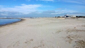 Ampia spiaggia sabbiosa, cielo sereno con qualche nuvola.