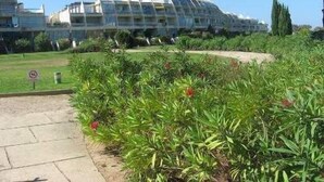 Un hotel moderno caratterizzato da un’originale struttura a cupola, circondato da giardini curati e un cielo sereno.