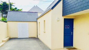 A narrow alleyway leading to a building with a blue door marked "Garage."