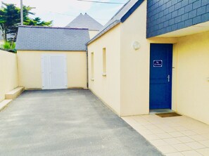 A narrow alleyway leading to a building with a blue door marked "Garage."