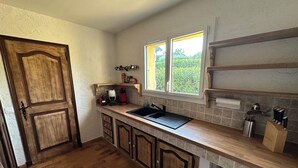 A kitchen with a wooden door, a window, a sink, and cabinets. - Family home with private pool, fenced garden, 500 meters from the beach. (La Croix-Valmer)