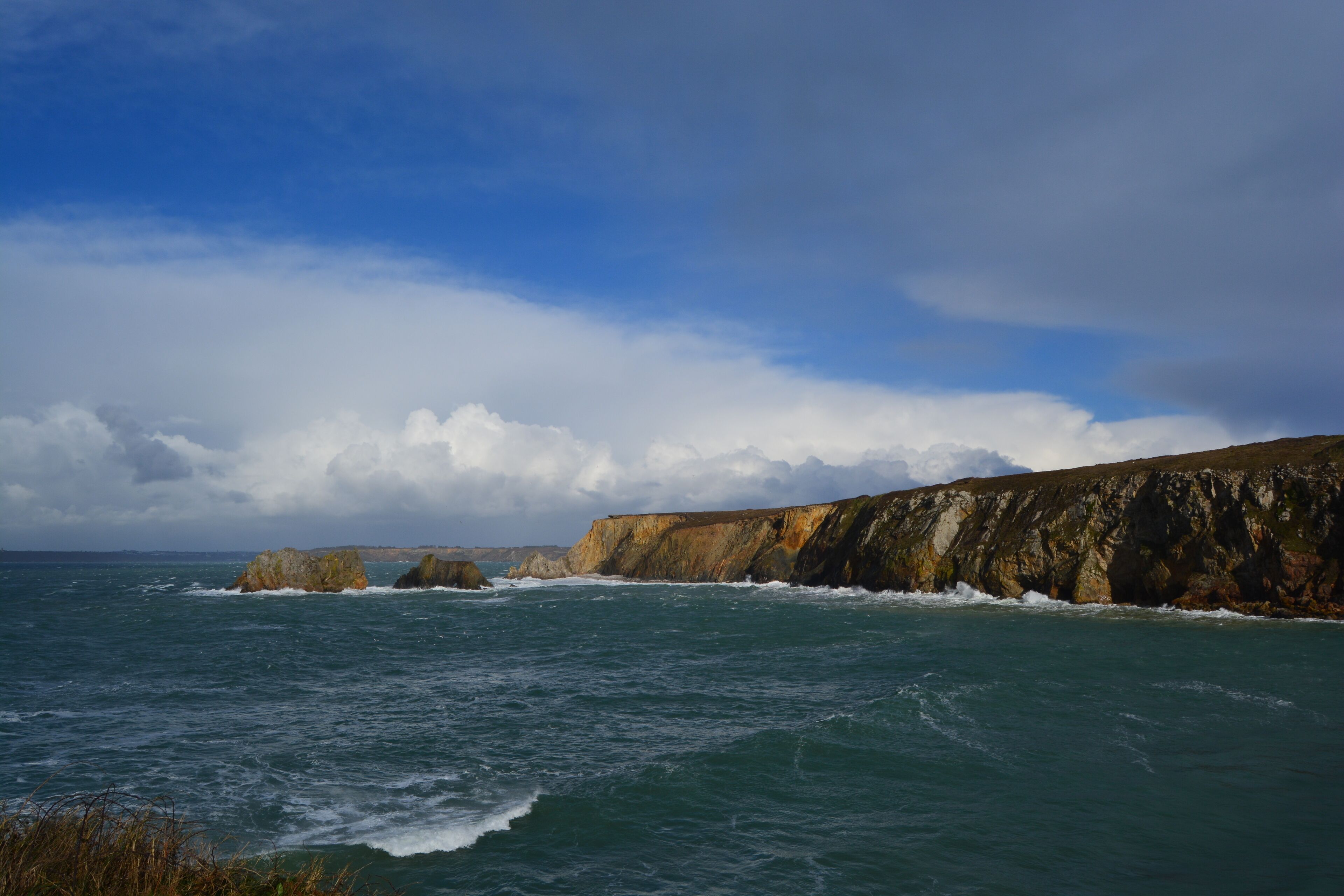 A coastal landscape with cliffs and the sea.