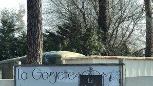 A sign with 'La Goyette' and 'Le Marché' written on it, with a cartoon frog and cow illustration.