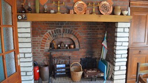 Une cheminée en briques avec une étagère au-dessus, sur laquelle sont disposés divers objets décoratifs.