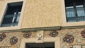 A building with a textured facade, multiple windows with shutters, and decorative mosaic patterns near the entrance. - Gîte Lo Bornat: full of nature and sun, between sea and mountains (Puissalicon)
