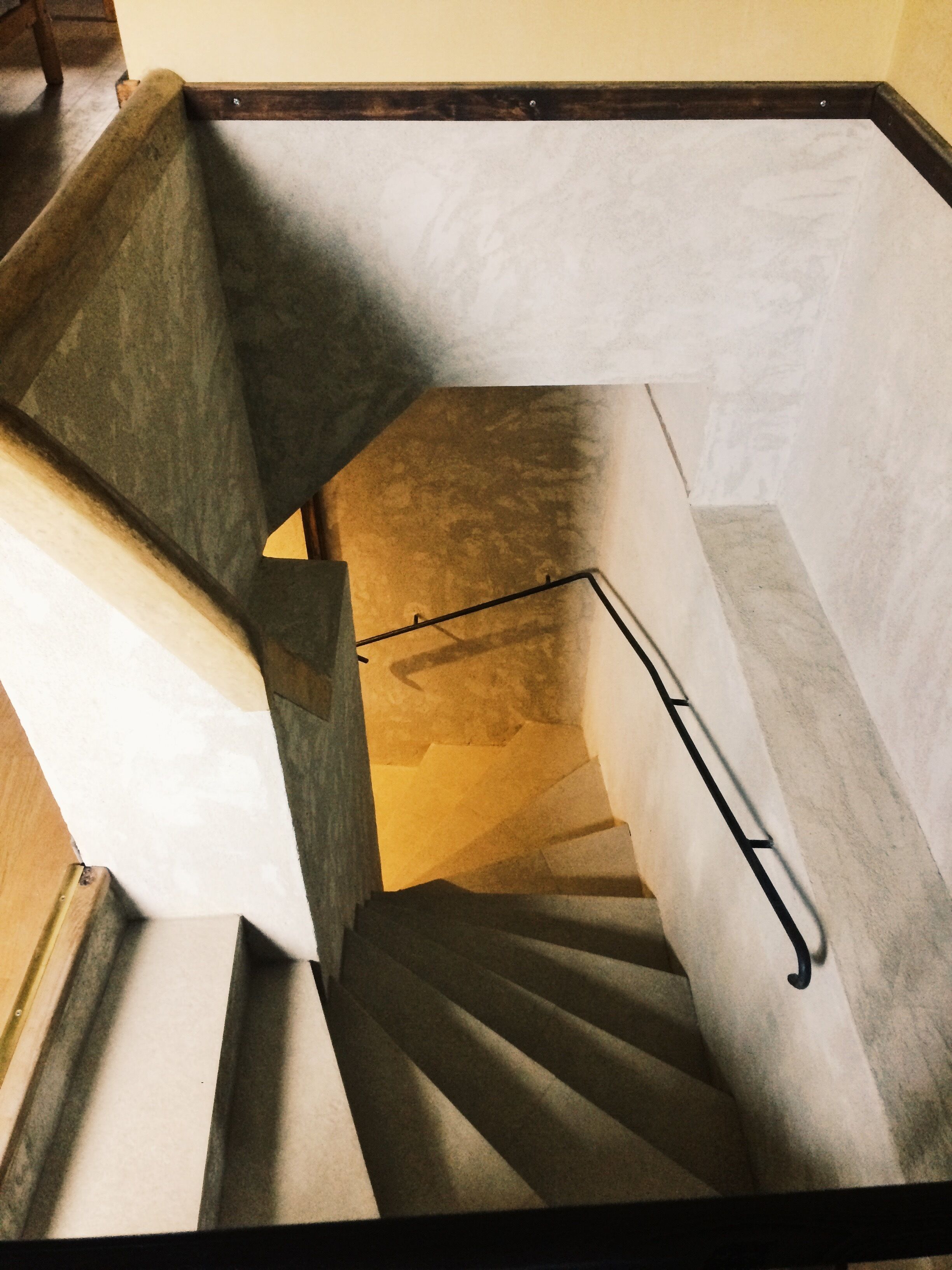 Un escalier doté d’une rampe, de marches en bois et d’un mur en béton.