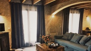A cozy living room with a sofa, a wooden coffee table, and a chair. - Gîte Lo Bornat: full of nature and sun, between sea and mountains (Puissalicon)